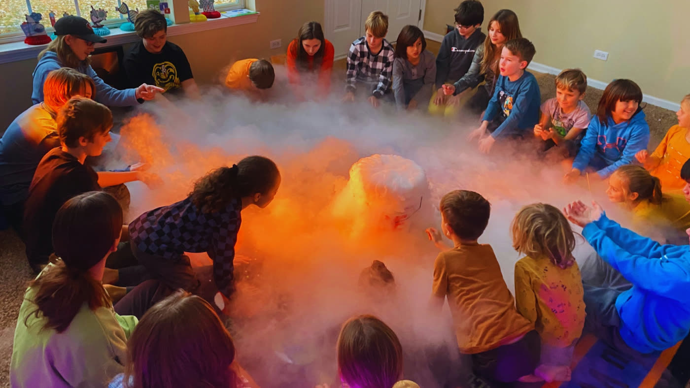 Children circled around a glowing science demonstration